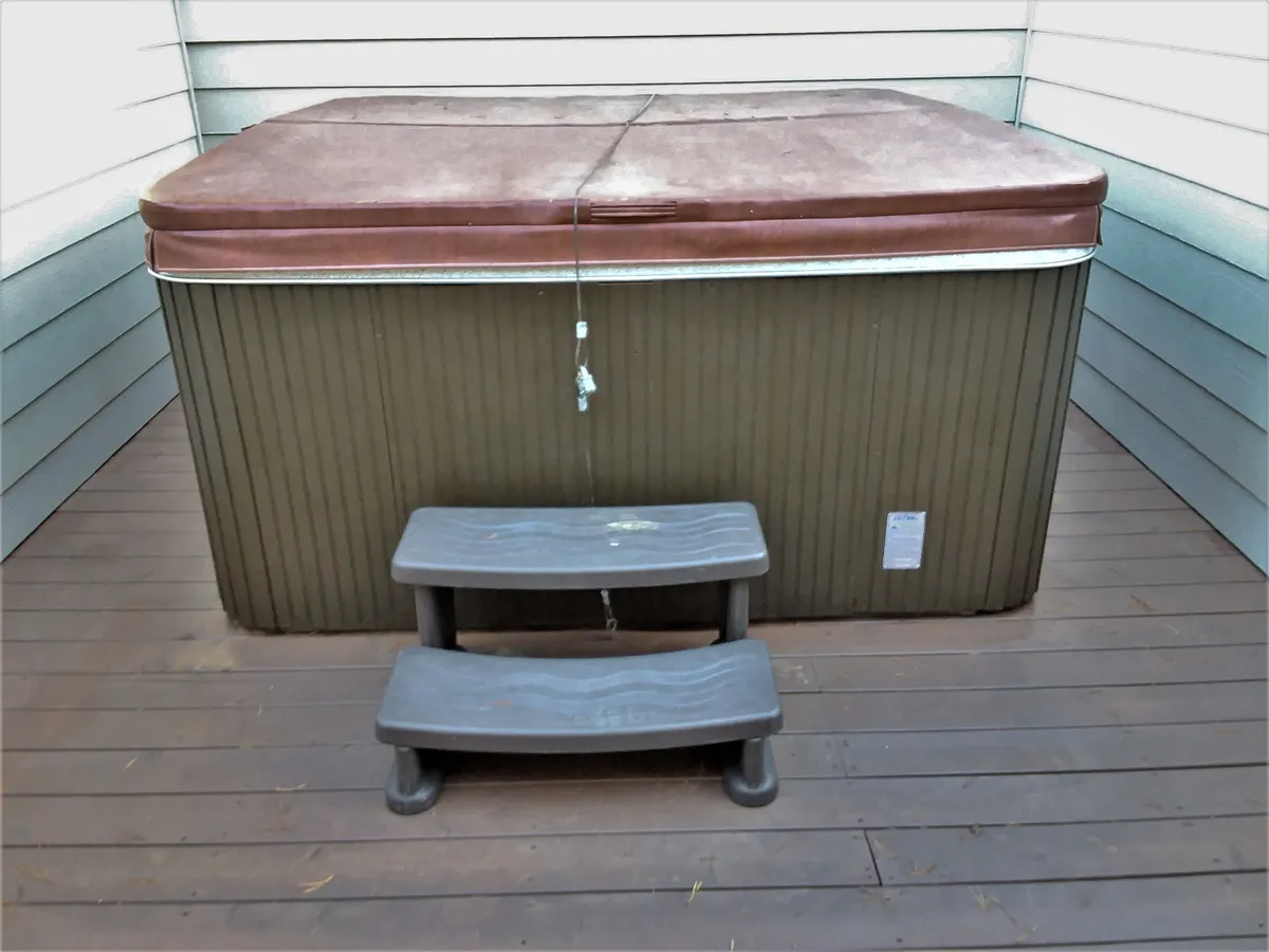 A private hot tub with a step stool, set in a calm indoor environment, ideal for relaxing after a day of adventure. The space feels serene and inviting, perfect for unwinding and socializing.